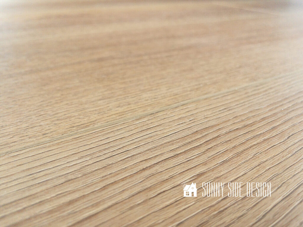 Close up view of luxury vinyl plank flooring, showing the realistic coloring and texture of the white French Oak floor.