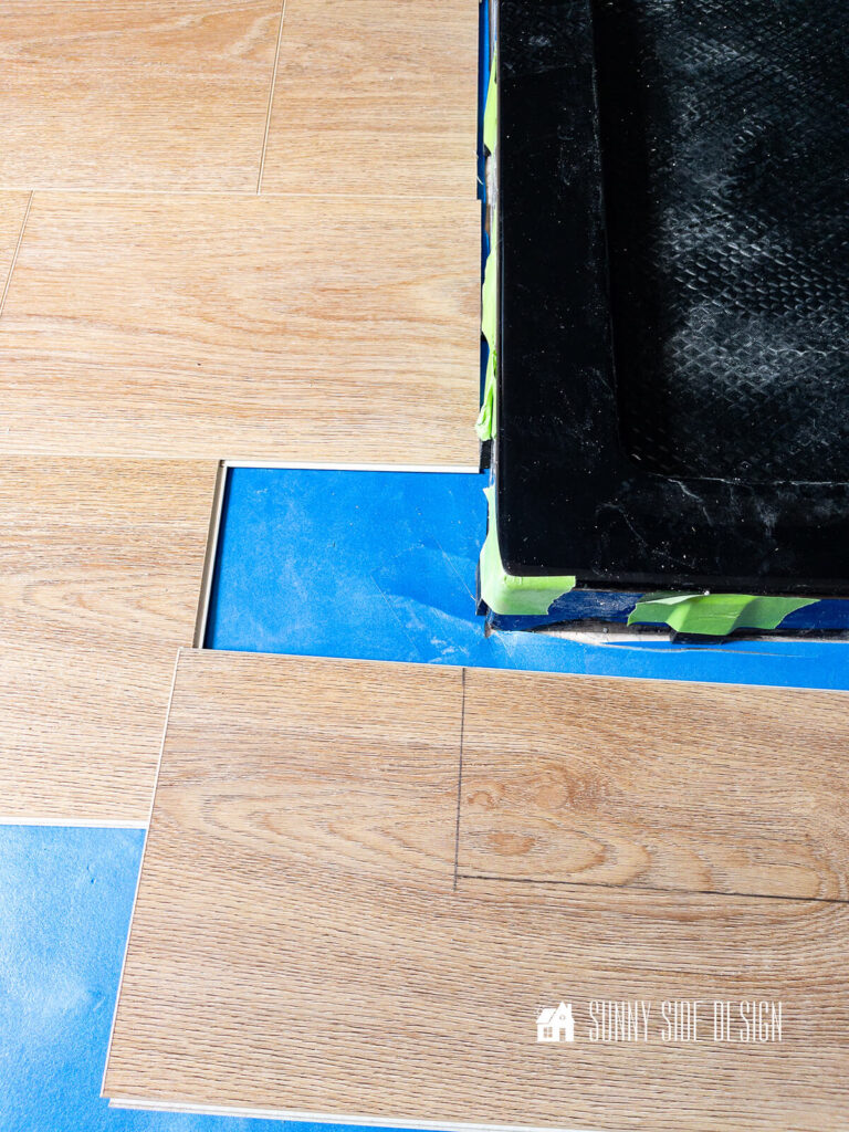 Mark with pencil the luxury vinyl plank floor area to be cut out to fit around the bathroom vanity.