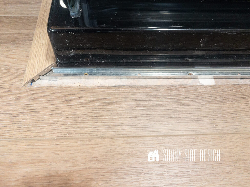 Metal transition frame is secured with screws around the shower base.