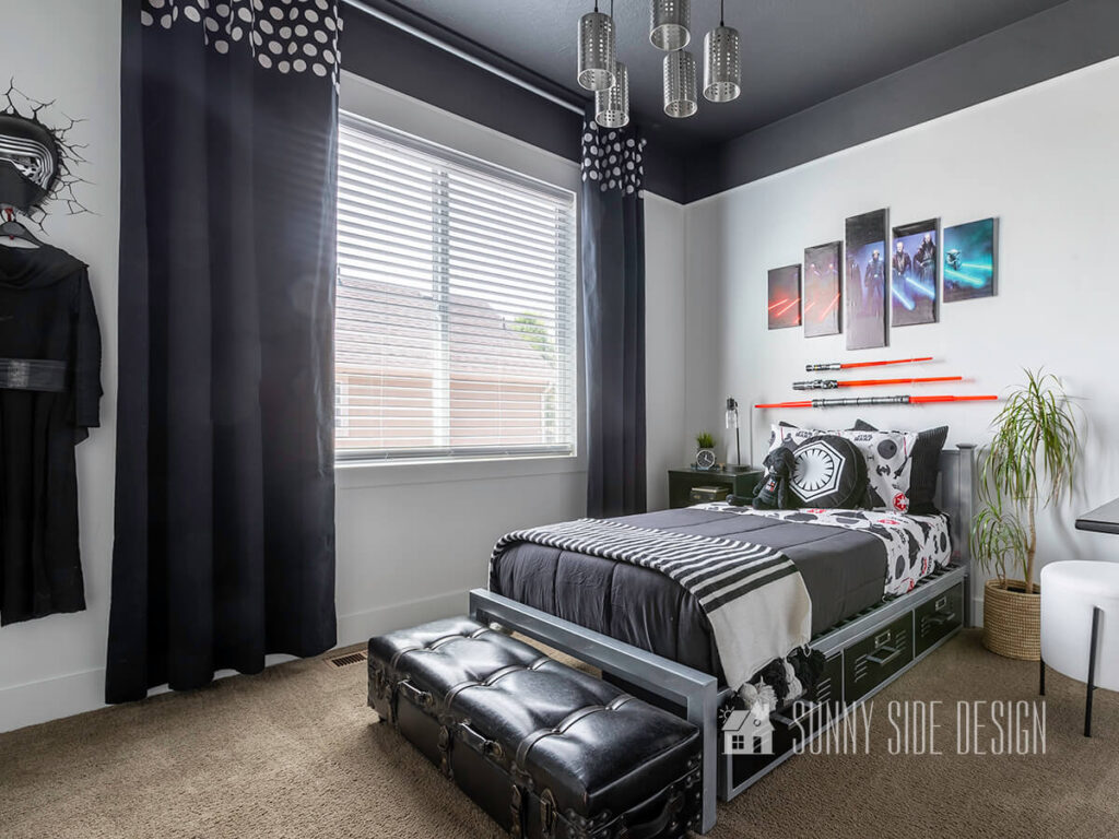 Home tour of Star Wars themed boys bedroom with a black ceiling, unique industrial light fixture, Star Wars art and lightsabers hung on the wall, Star Wars bedding and black curtains with white polka dot border.