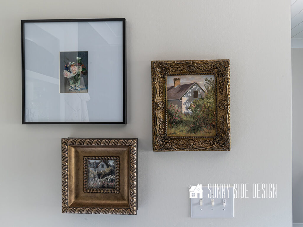 Small gallery wall in bathroom with original art along with free printable wall art sourced from The National Gallery of Art. One in a modern black frame with a wide white mat, two pieces in vintage antique gold frames.