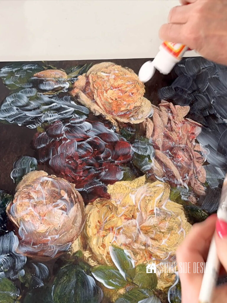 Woman applies glossy Modge Podge over a piece of printed vintage art.