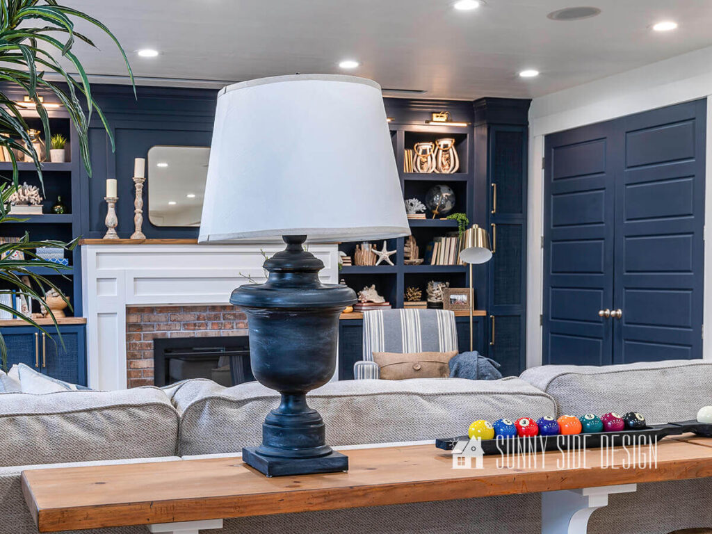 Dated brass lamps are updated with black spray paint and white wax in thie family room with navy blue built-ins.