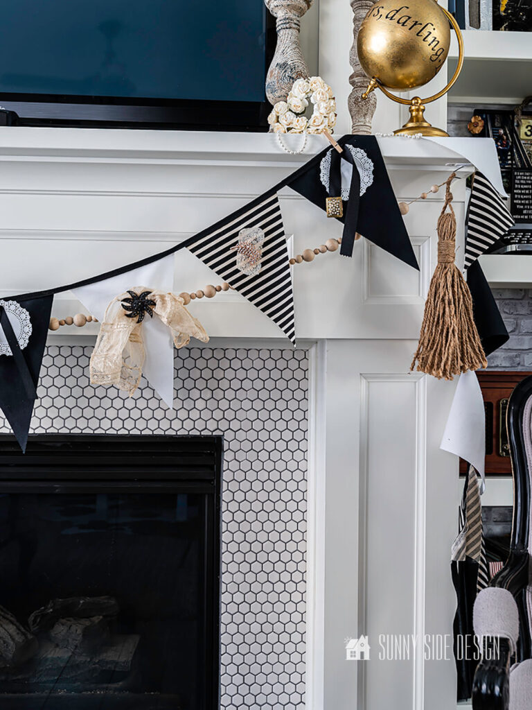 Vintage costume jewelery is repurposed on a black and white bunting with lace and doilies.