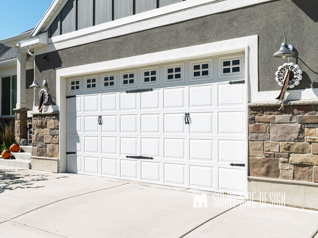 Halloween decorating ideas for outdoor garage lights: Simple $3 skull wreaths are hung on lights and embellished with Halloween colored ribbon.