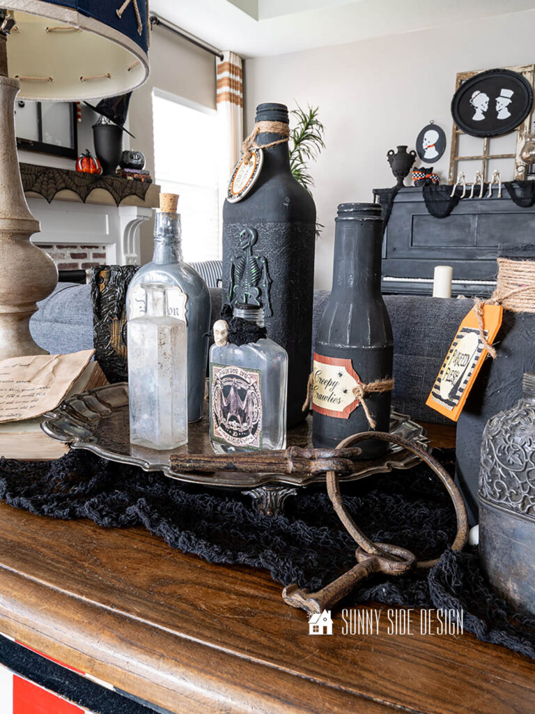 Bombay dresser is decorated with witch potion bottles on a vintage tarnished silver tray, styled with a vintage key ring.