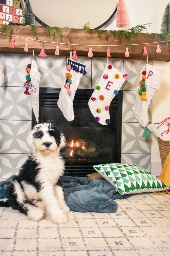 Christmas Decorating Ideas for Mantle colorful Boho vibe with yarn tassle garland, pastel Christmas countdown tree and bottle brush trees.