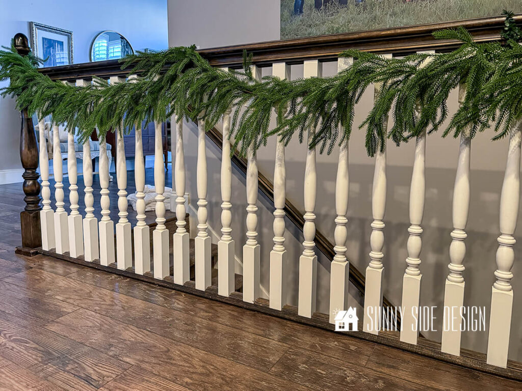 Faux pine garland hung on railing.