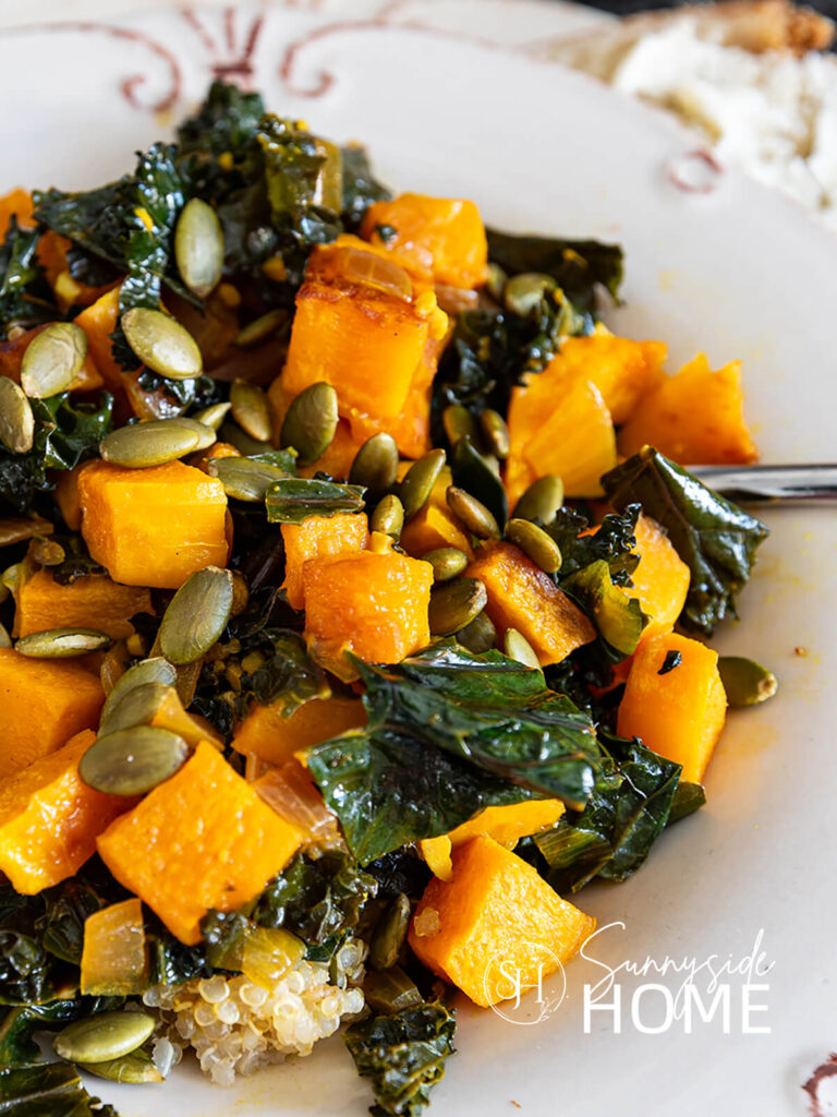 Curry butternut squash and kale served over quinoa and garnished with roasted pepitas.