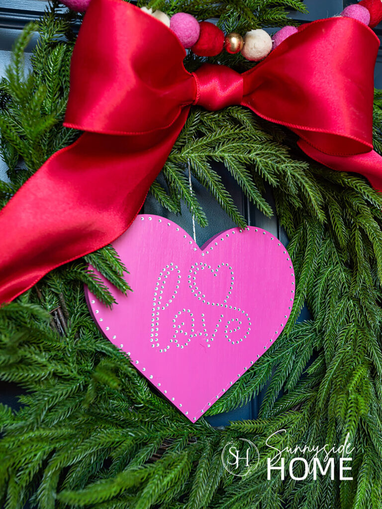 Easy DIY Valentine Wreath: fushia heart embellished with rhinestones and a big red bow.