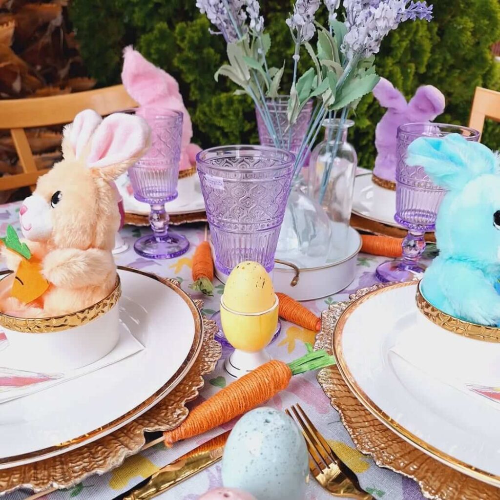 Small stuffed colorful Easter bunnies personalize each Easter place setting, table also decorated with jute carrots, lavender goblets and colorful eggs.