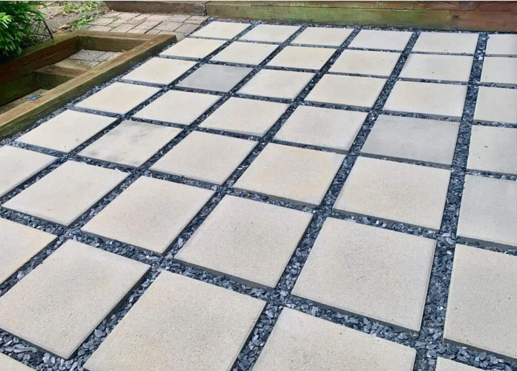 Modern 12x12 concrete pavers with crused black granite filling the spaces.