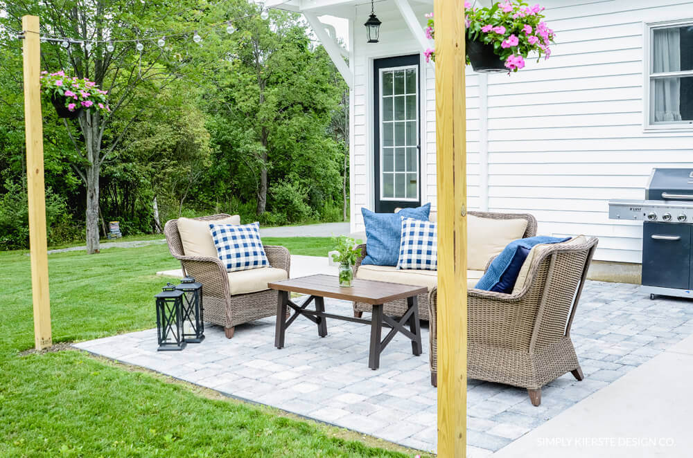 Simple paver patio ideas: gray pavers with 4x4 post to support outdoor stringlights. Styled with an outdoor seating area.