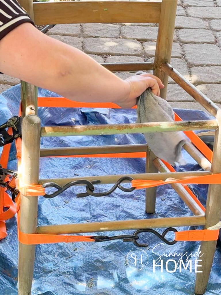 Woman removes excess glue after repairing the vintage chair.