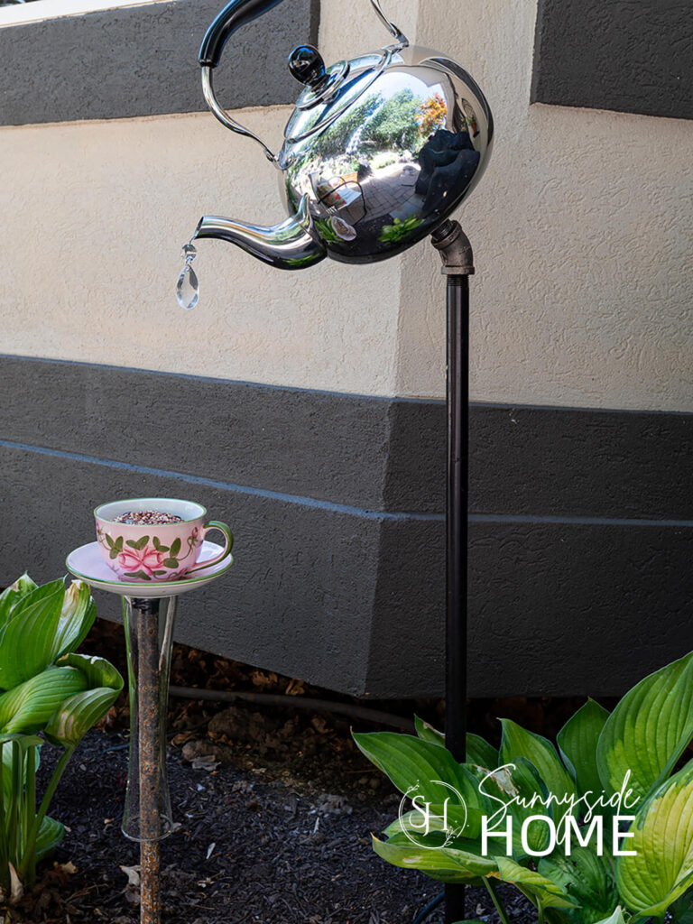 Garden teapot decor placed in the flower garden.