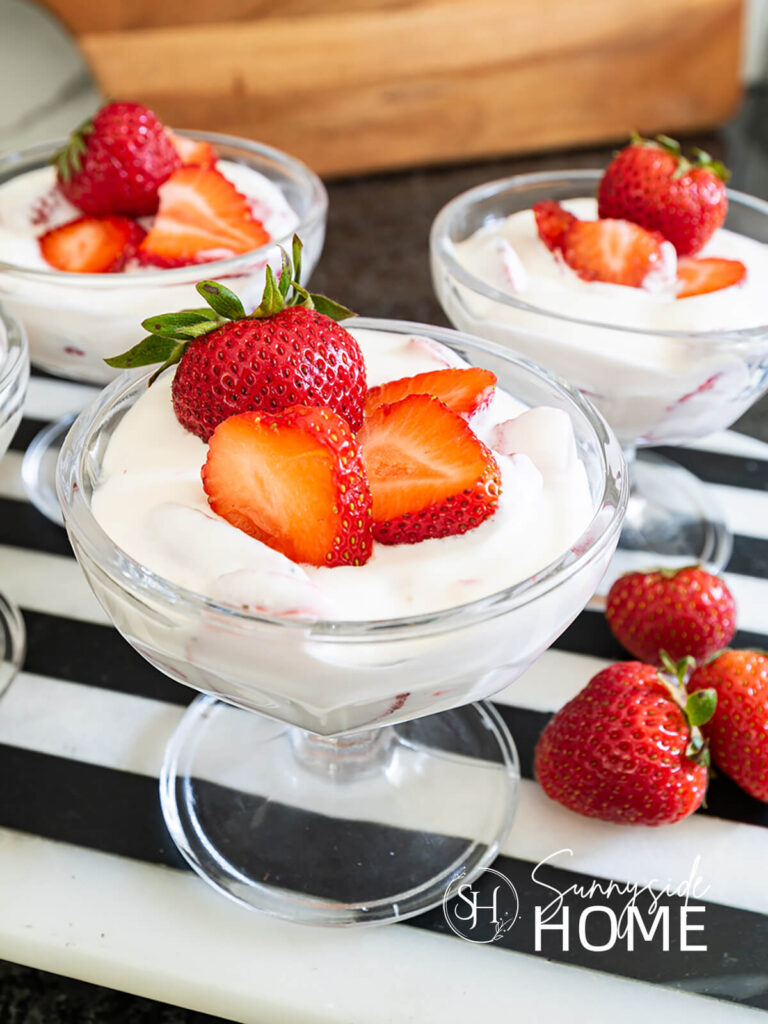 Mexican strawberries and creme in a glass dessert dish garnished with fresh strawberries.