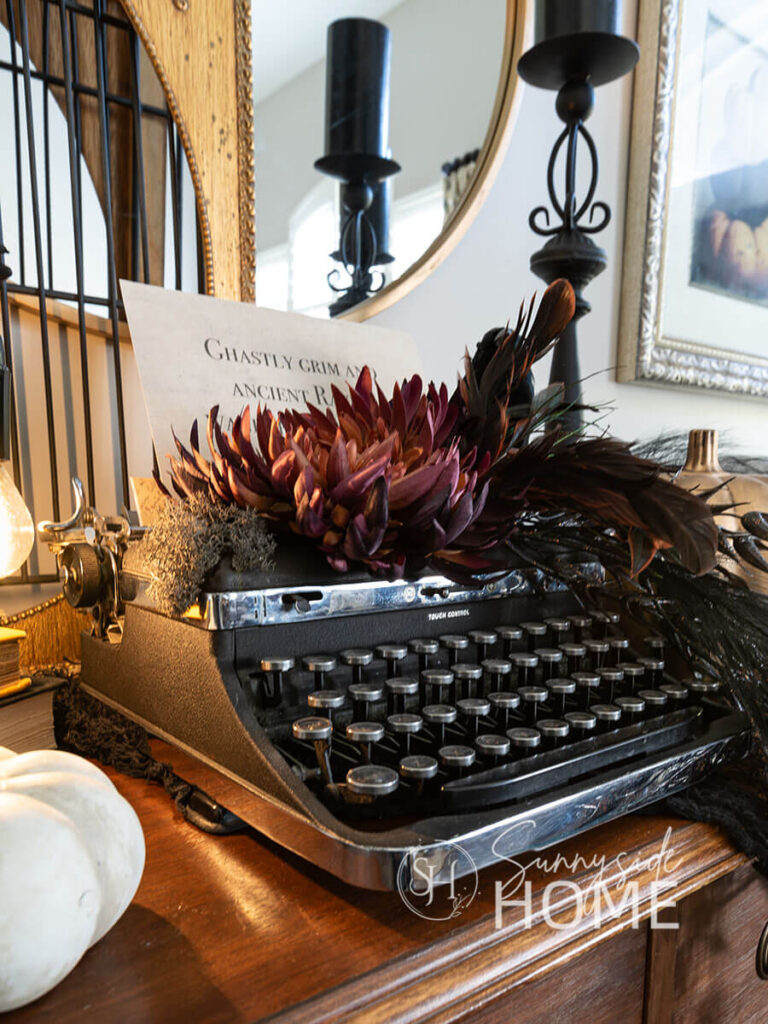 Decorating for Halloween, vintage typewriter with a line from Edgar Allen Poe and embellished with birds an spooky faux flowers.