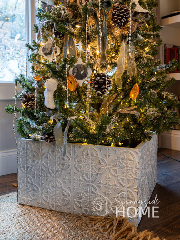 Finished Christmas tree collar using Dollar Tree Tiles at the base of a decorated Christmas tree.