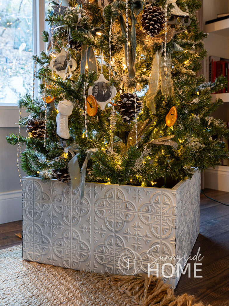 Finished Christmas tree collar using Dollar Tree Tiles at the base of a decorated Christmas tree.