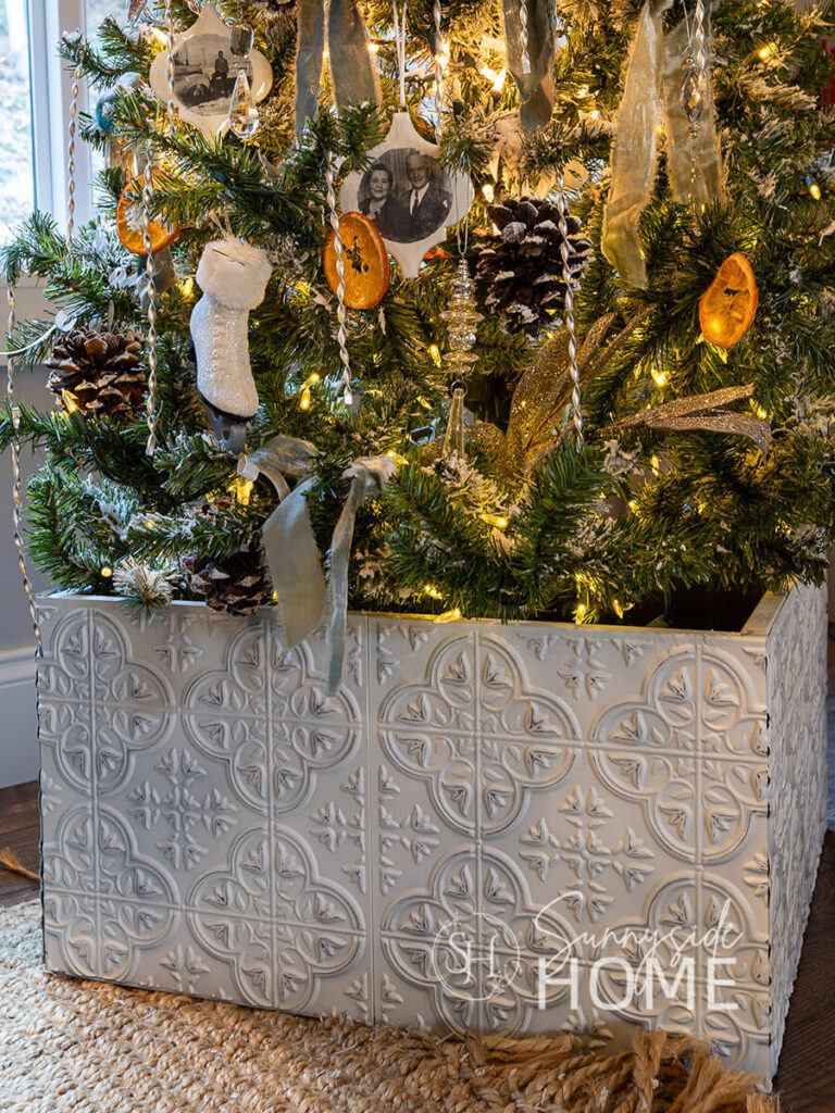 Finished Christmas tree collar using Dollar Tree Tiles at the base of a decorated Christmas tree.