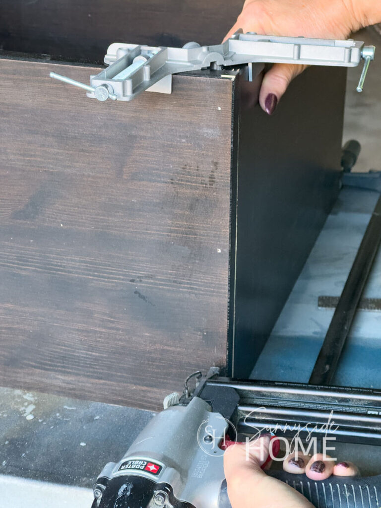 Woman secures box with brad nails.