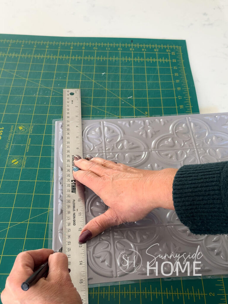 Woman trims Dollar Tree tile with an craft knife.