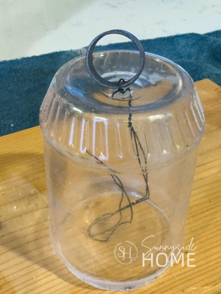 Recycled peanut butter container with a ring wired to the top for DIY bells.