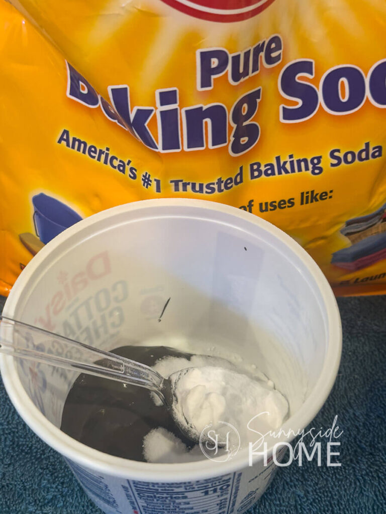 Baking soda is mixed into charcoal grey paint to add texture for recycled Christmas bells project.