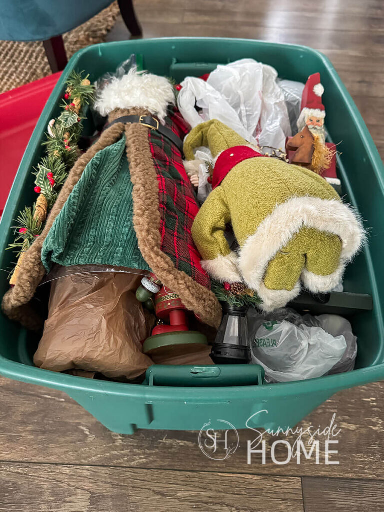 Santas are stored in a large Christmas bin.