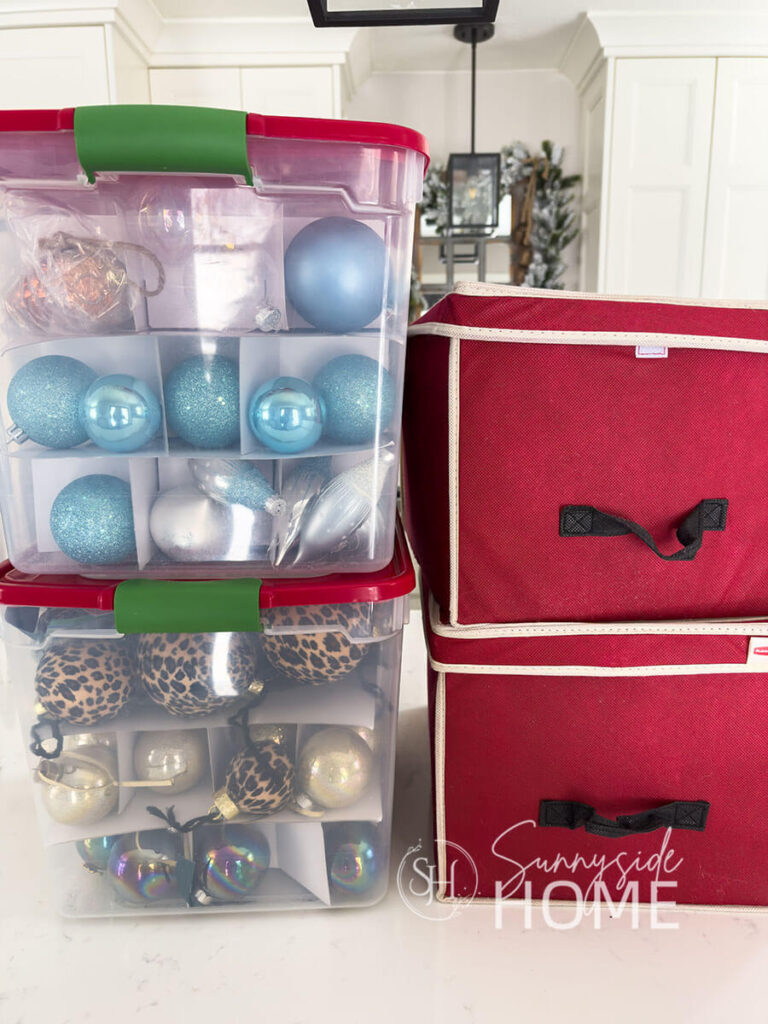 Clear plastic totes and red canvas bins are used to store and organized Christmas decorations.
