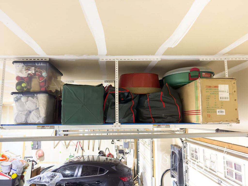 Overhead garage storage is used to store and organize Christmas decorations.