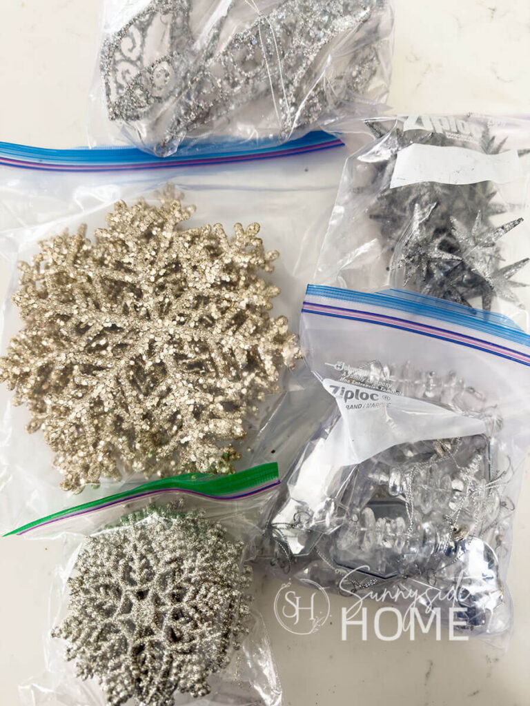 Glittered snowflakes and ornaments are stored and organized in ziplock bags, then placed in a storage bin.