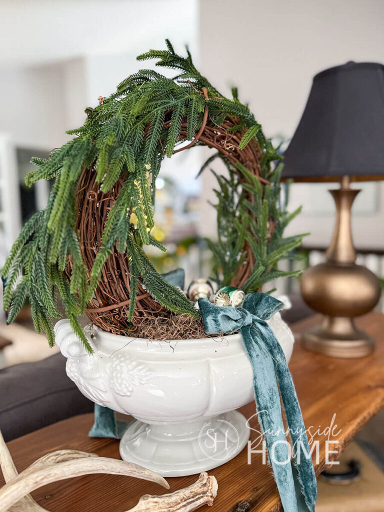 DIY Norfolk pine stem topiary, embellished with blue velvet bows and vintage glass ornaments.