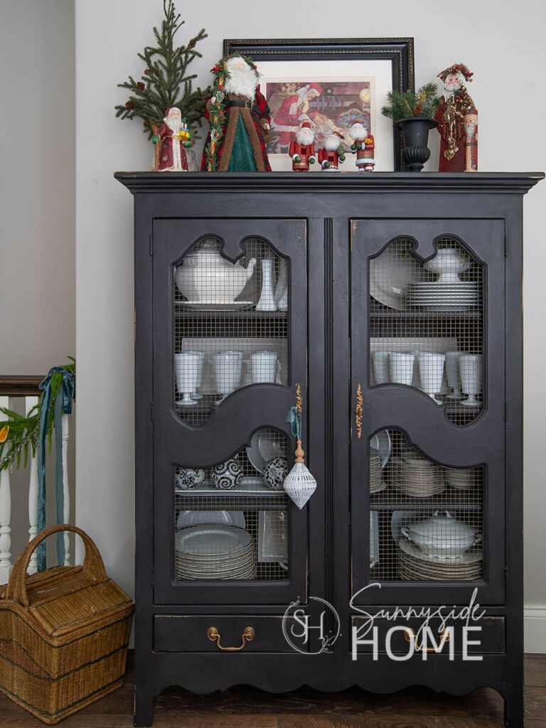 The black china hutch is decorated with a vintage Santa collection.