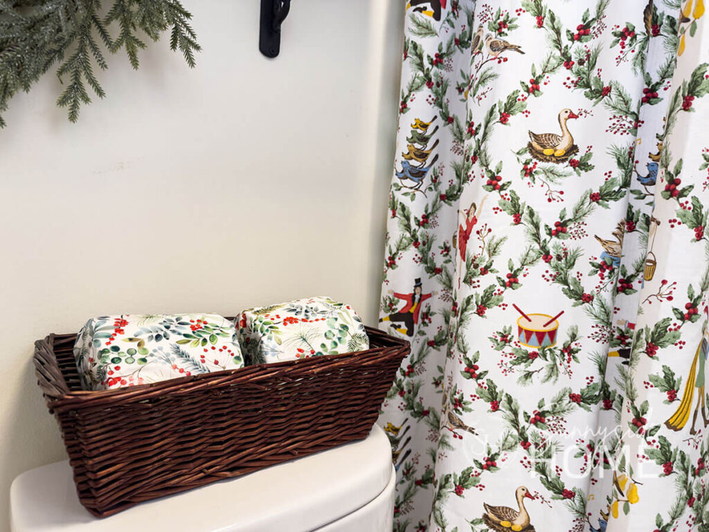 Extra toilet paper is given a festive touch by wrapping it in Christmas print tissue paper.