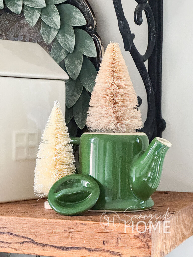 Sisal tree in a green vintage teapot on an open shelf in the kitchen.