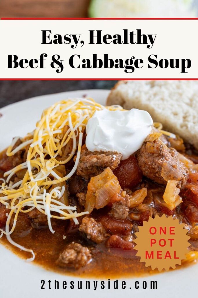 Pinterest image Easy Beef & Cabbage Soup served with a slice of sour dough bread. Soup ingredients include beef, cabbage, tomatoes, peppers and black beans.
