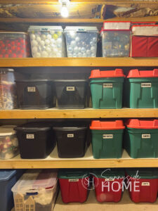 Labeled storage bins arranged on the finished basement storage room shelves.