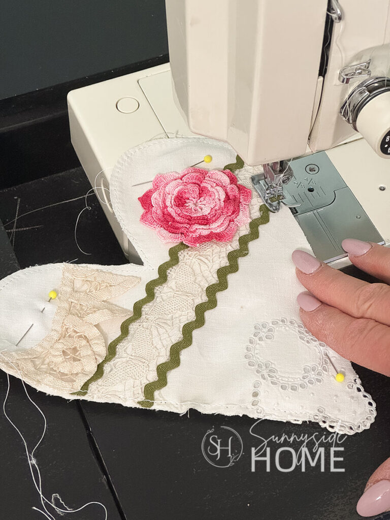Embellished vintage linens with vintage lace and trim is stitched together with a narrow seam on a sewing machine.