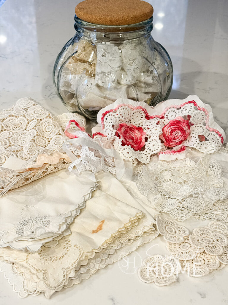 A collection of vintage linens, lace and trims that will be used to create Valentine heart decor.