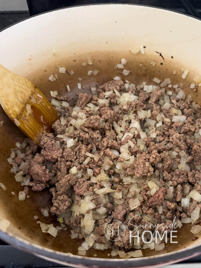 Cooked ground beef and onions in a pot.