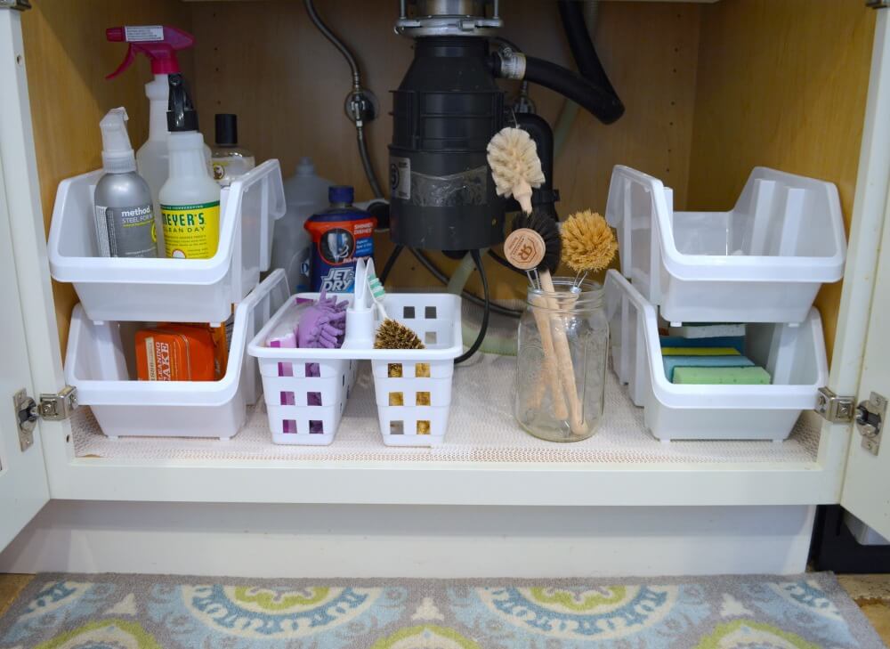 Organizing under kitchen sink with Dollar Tree caddy and stackable bins on a budget.