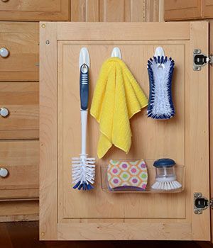 Kitchen brushed, sponge and clothes are stored on the cabinet door with command hooks.