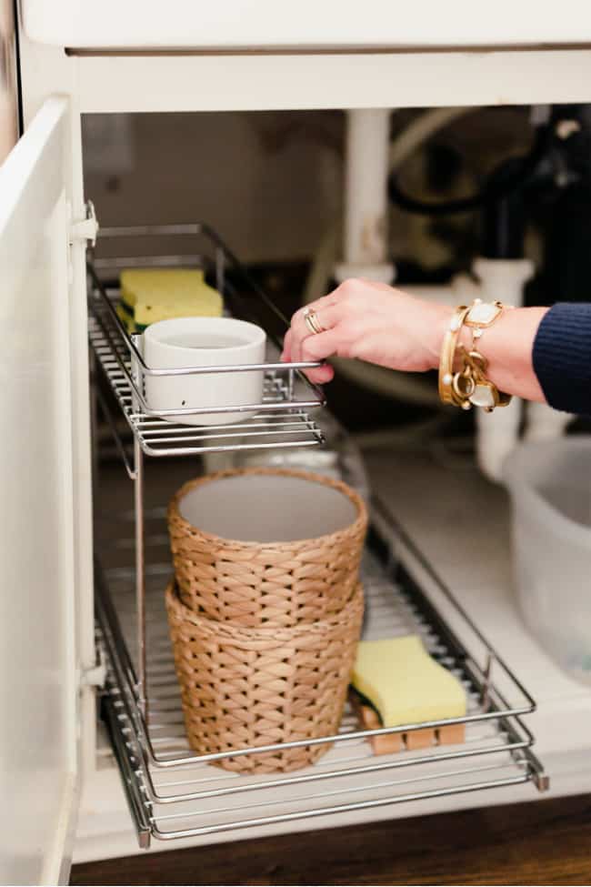 A stainless steel tiered sliding tray makes organizing around the plumbing easier.