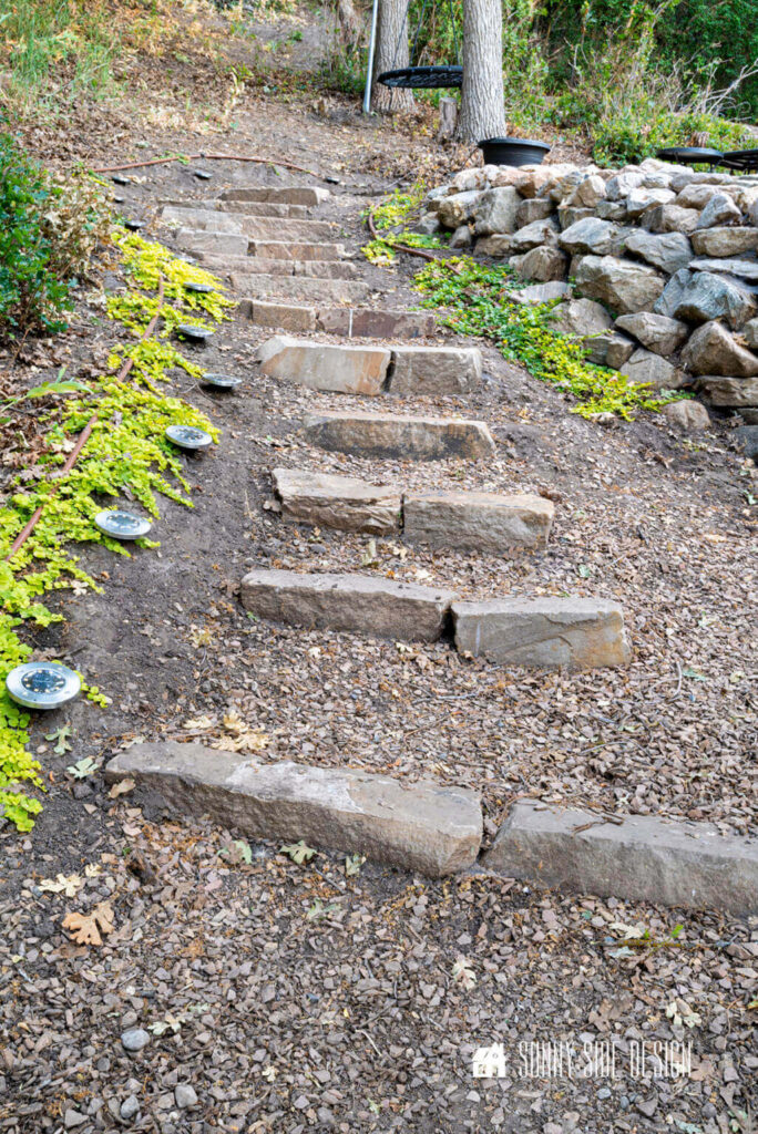 Stack stone Landscape steps on a sloape in a backyard leading to the fire pit aea.