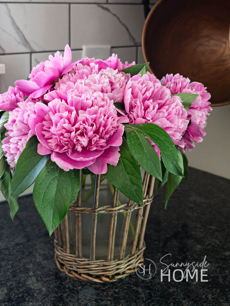 Styled pink peonies in a vase, with tips for how to make peonies last longer in a vase.