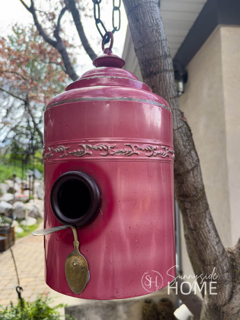 Final How to Make a Birdhouse with Thrift Store Finds, A red canister is upcycled into a charming garden birdhouse.