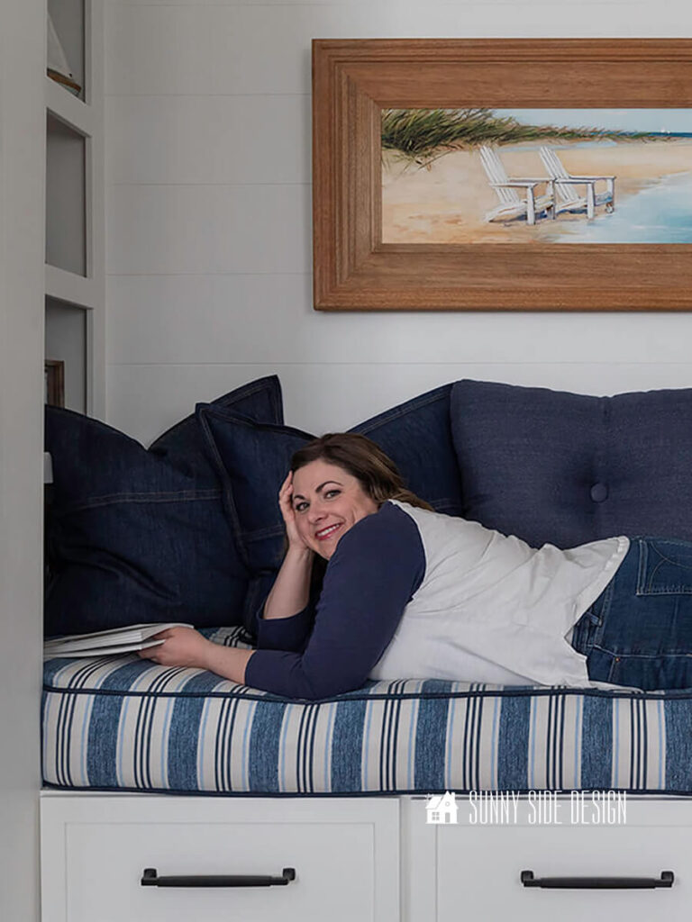 An unused closet is covered to a cozy reading space with a cushion, pillows and built in bookshelves.
