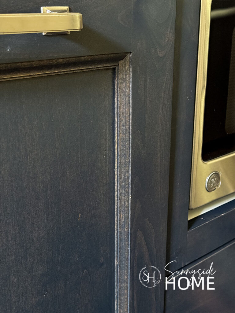 Dark stained Kitchen cabinet door with chips that need fixing.