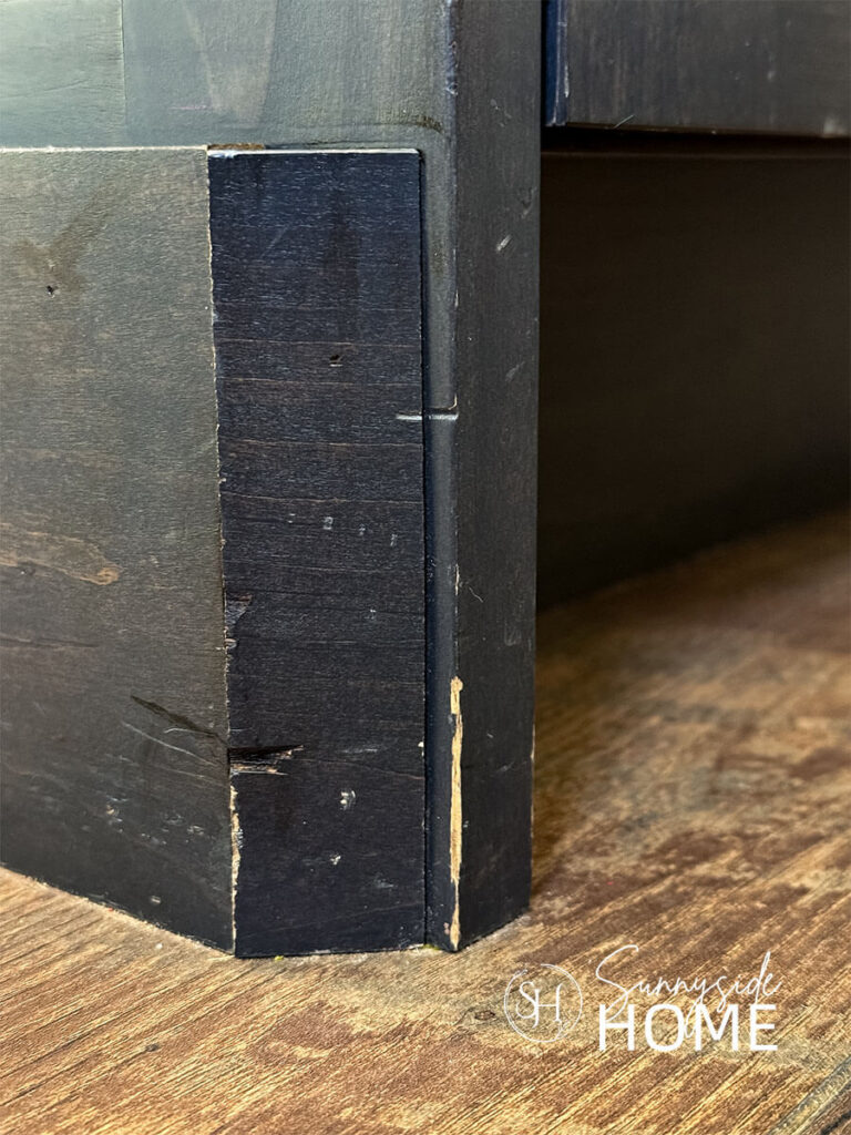 Base of kitchen cabinet with chipped finish.